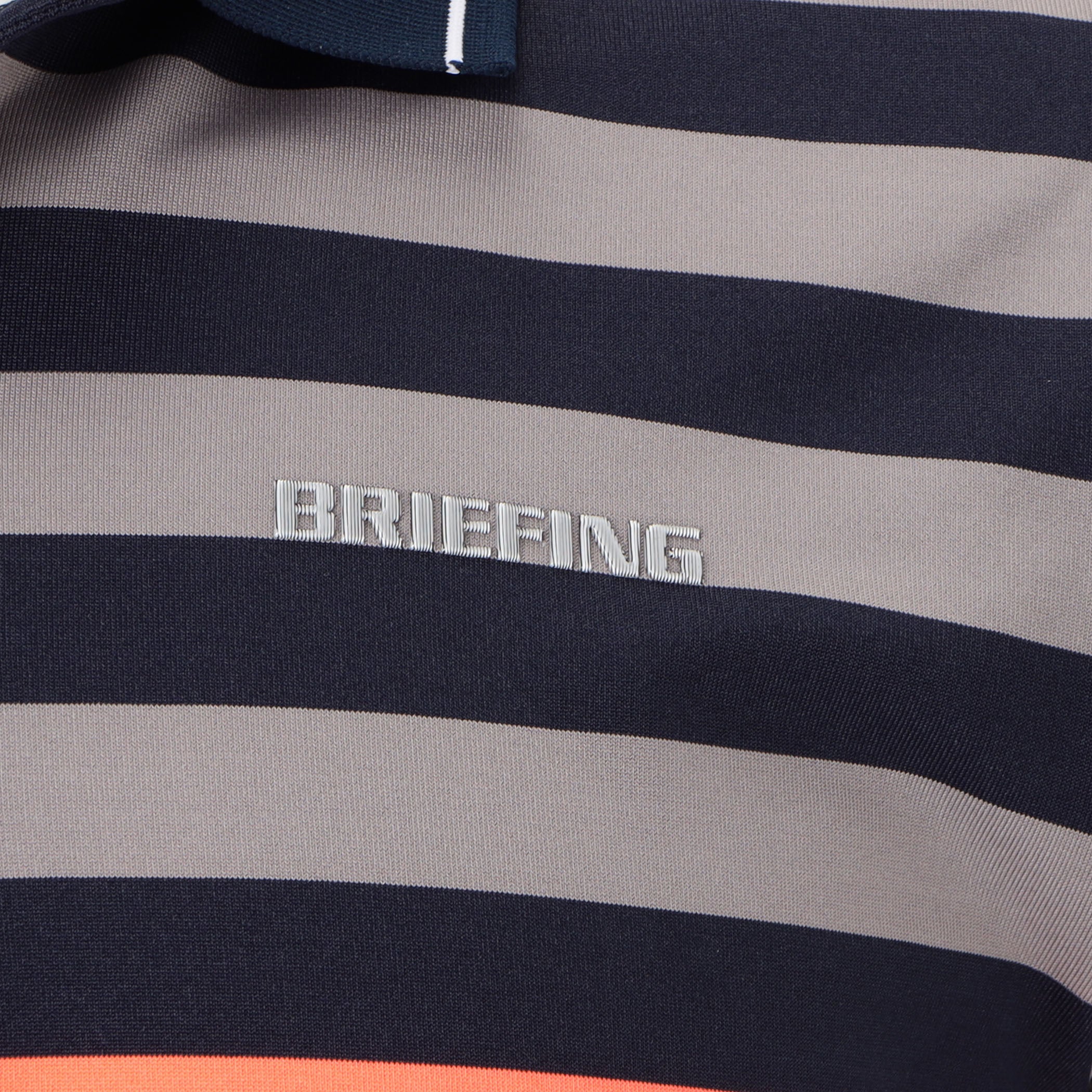 見る角度によって色味や光沢が変化して見えるBRIEFINGロゴを胸元に配置。