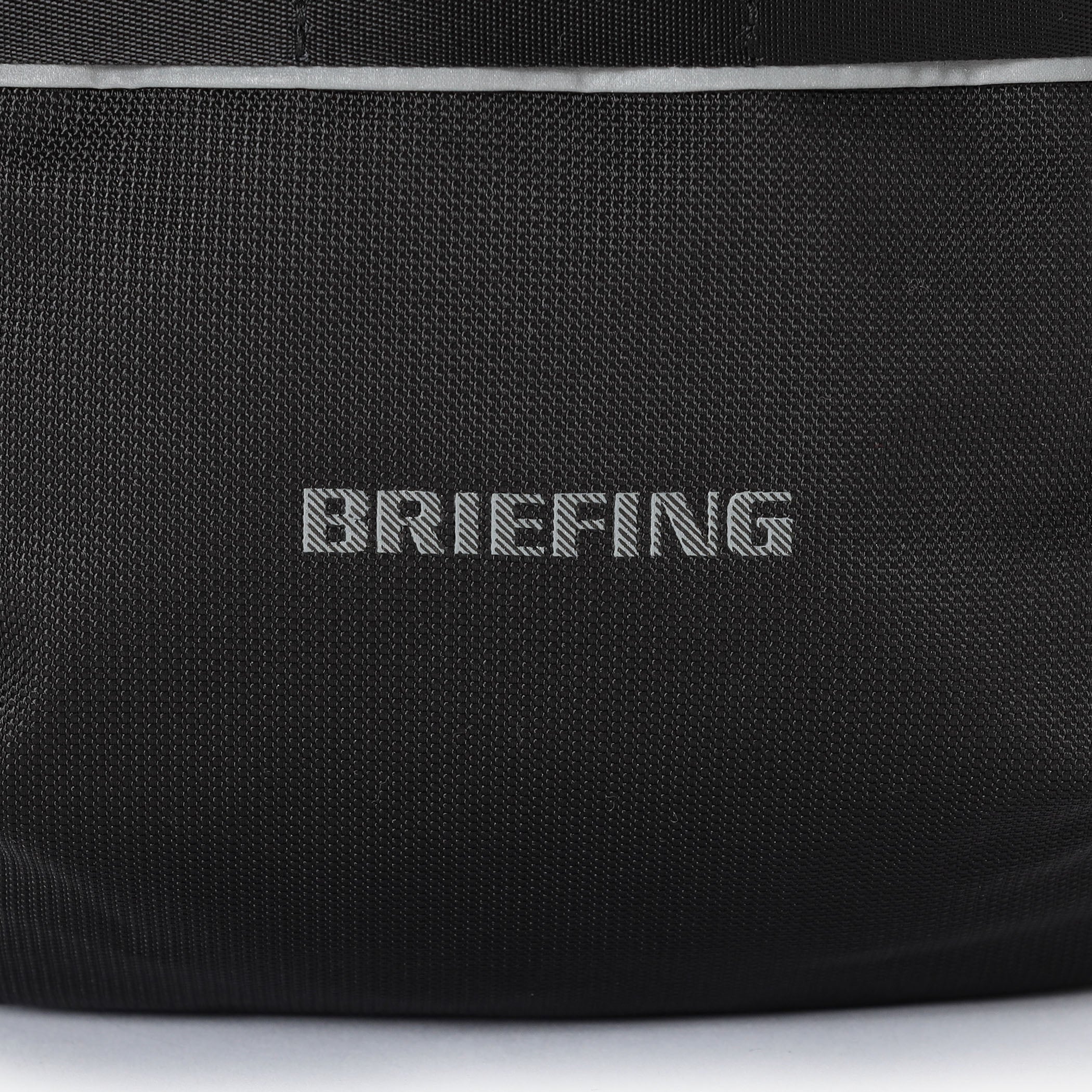 夜間時の移動に配慮し、フロントのBRIEFINGロゴとウェビングテープの下側はリフレクター仕様に。