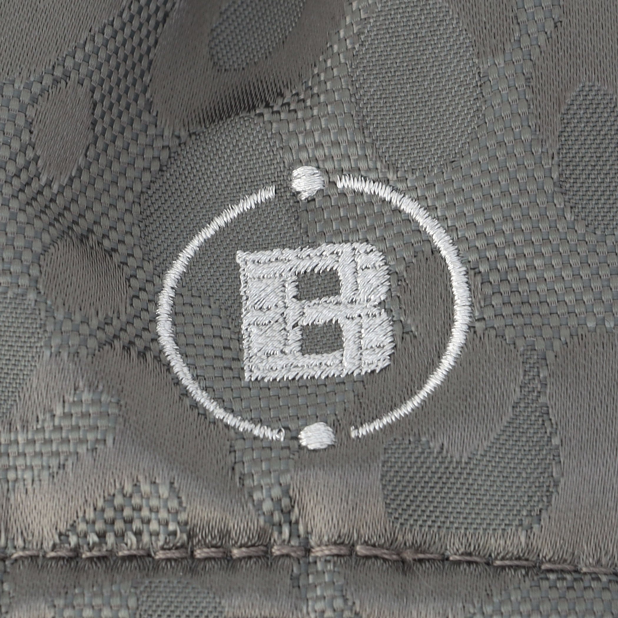 各所に配したロゴ刺繍には、素材の風合いにマッチするシルバーカラーを採用。格子のような柄が浮き出る特別な刺繍をあしらっています。