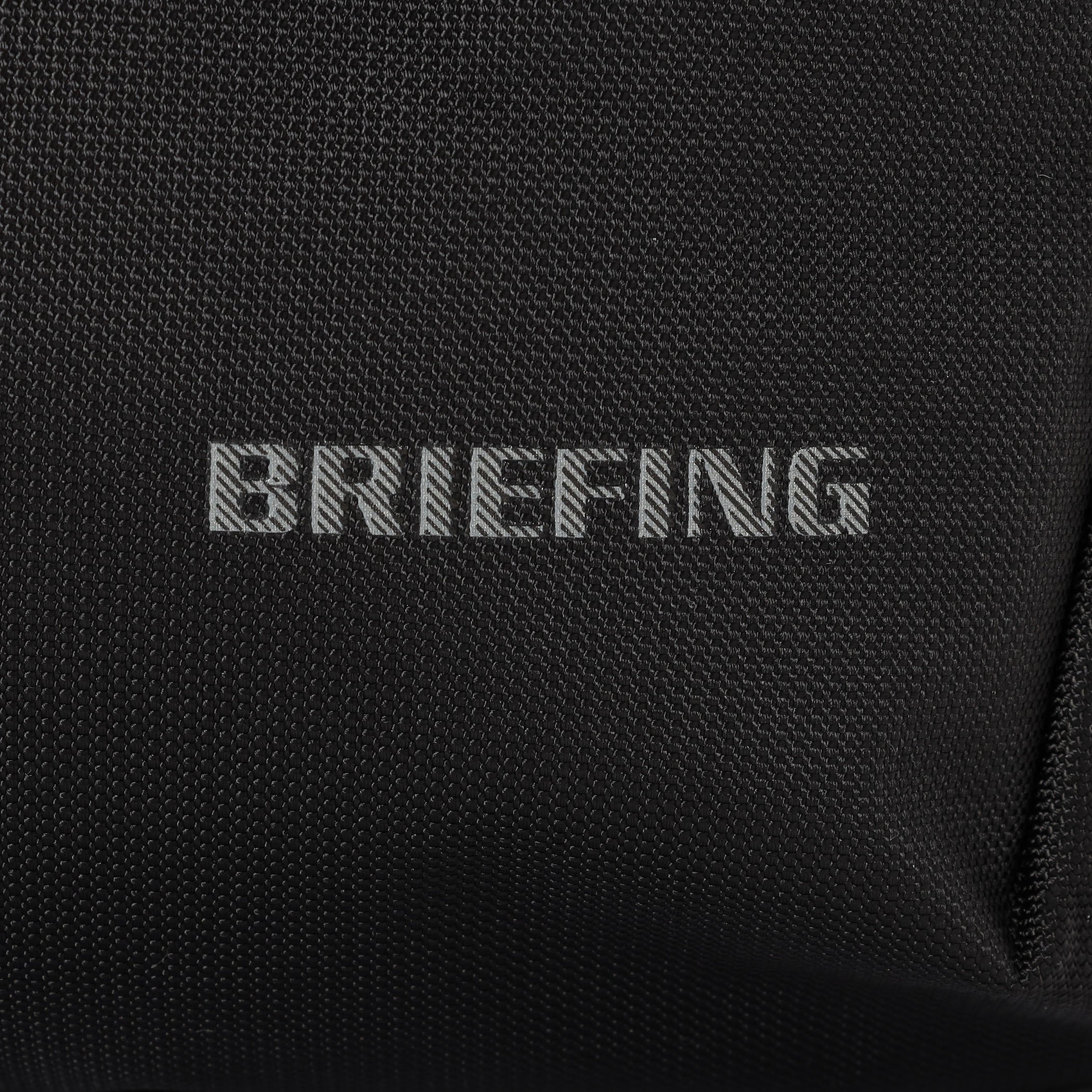 夜間時の移動に配慮し、フロントのBRIEFINGロゴとウェビングテープの下側はリフレクター仕様に。