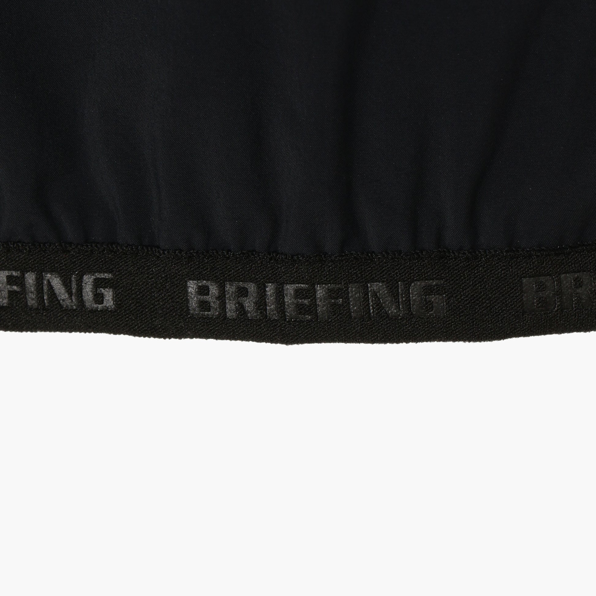 袖口、裾にあしらわれた、BRIEFINGのエンボスロゴ入りパイピングテープ。