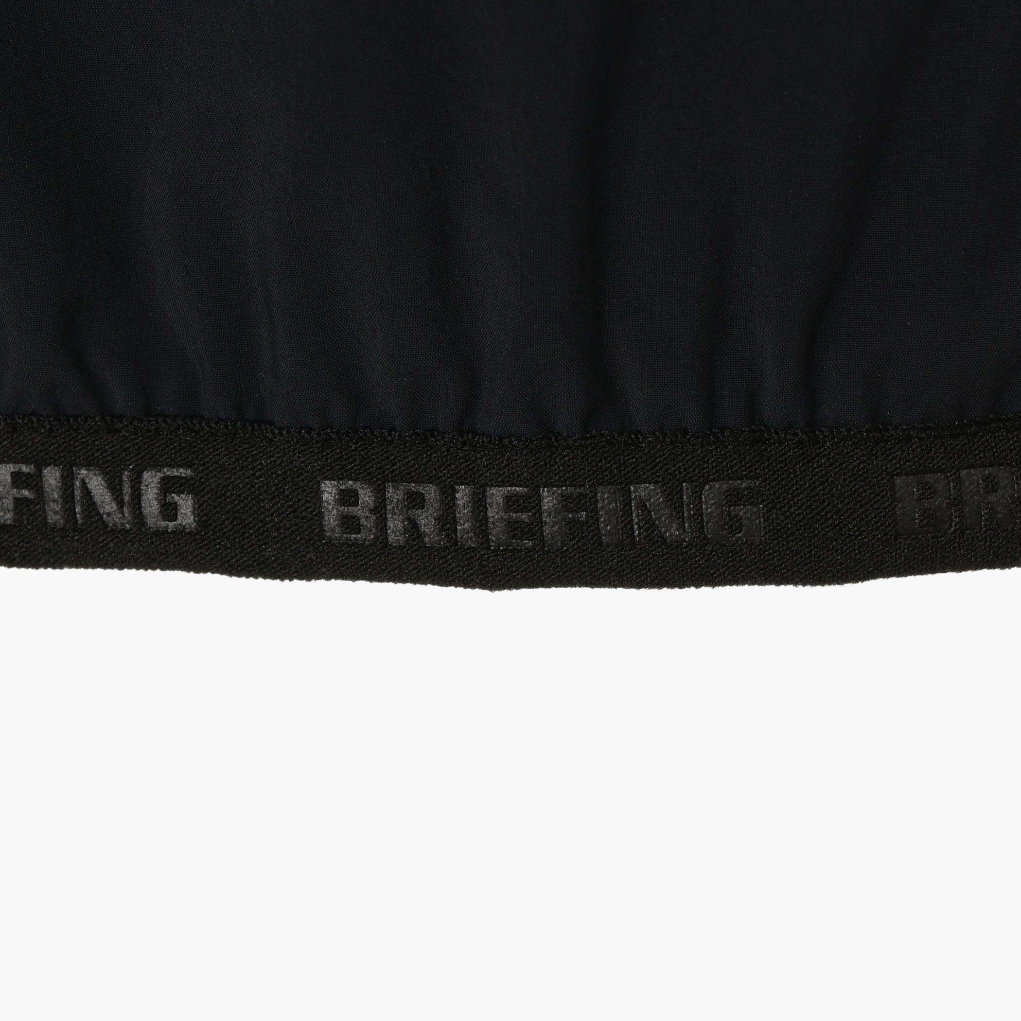 袖口、裾にあしらわれた、BRIEFINGのエンボスロゴ入りパイピングテープ。