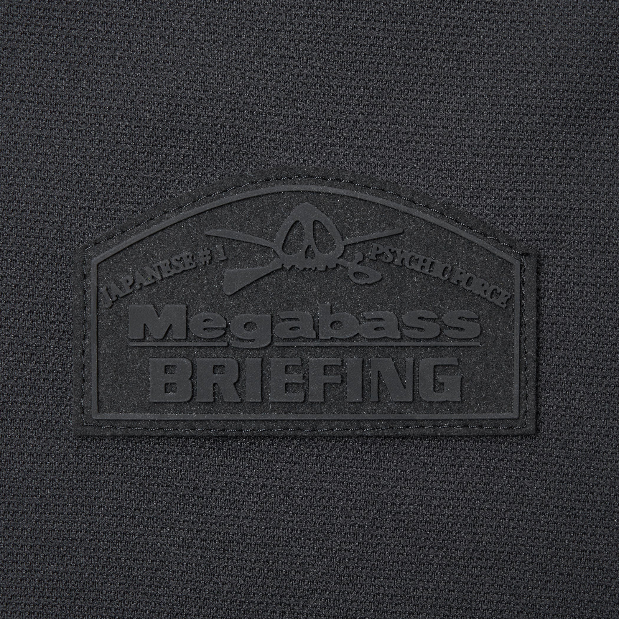 胸元にはコラボの証であるMegabassとBRIEFINGダブルネームのワッペンを配置。