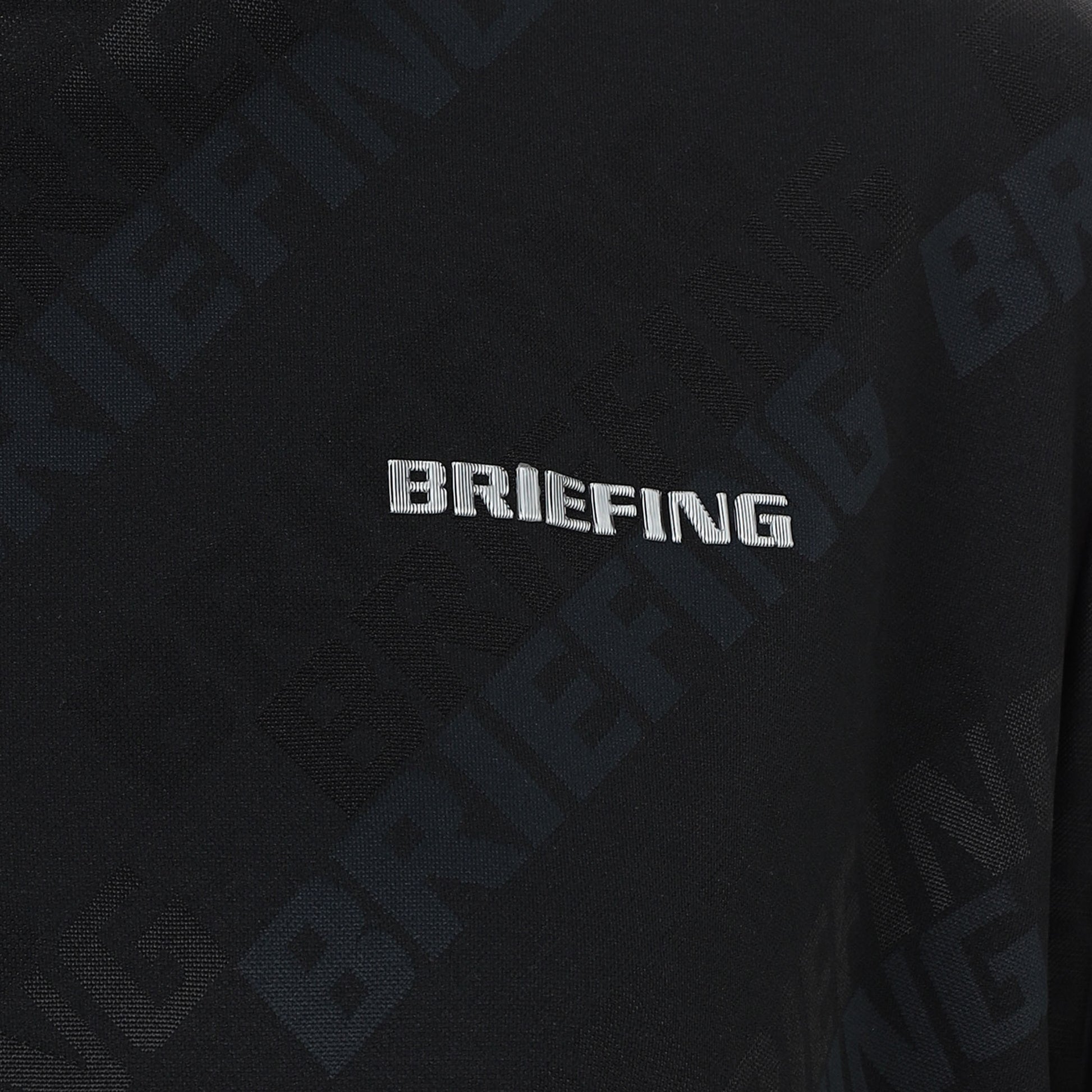 見る角度によって色味や光沢が変化して見えるBRIEFINGロゴを胸元に、Bマークロゴをバックネックに配置。