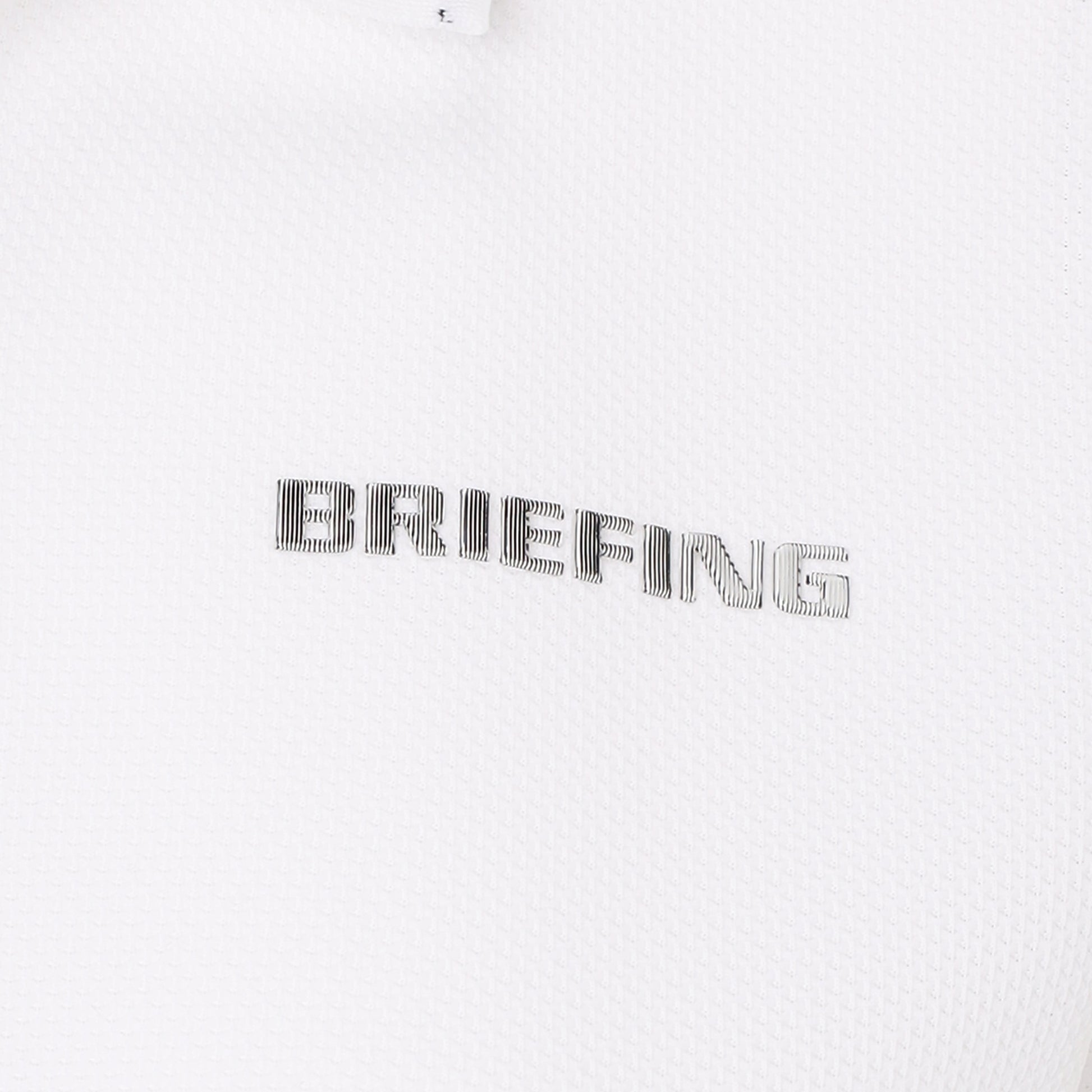見る角度によって、色みや光沢に変化のあるBRIEFINGロゴを胸元に、袖口にはBマークを配置。