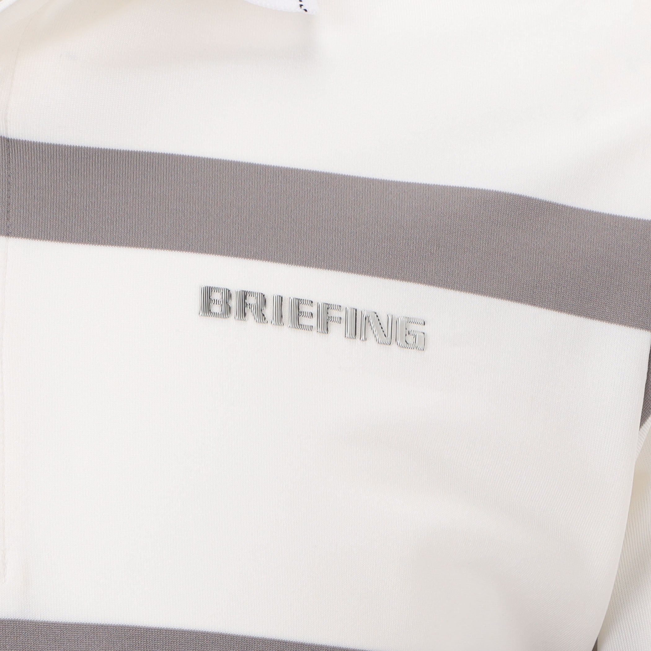 見る角度によって光沢や色味が変化する立体的なBRIEFINGロゴを胸元に配置。