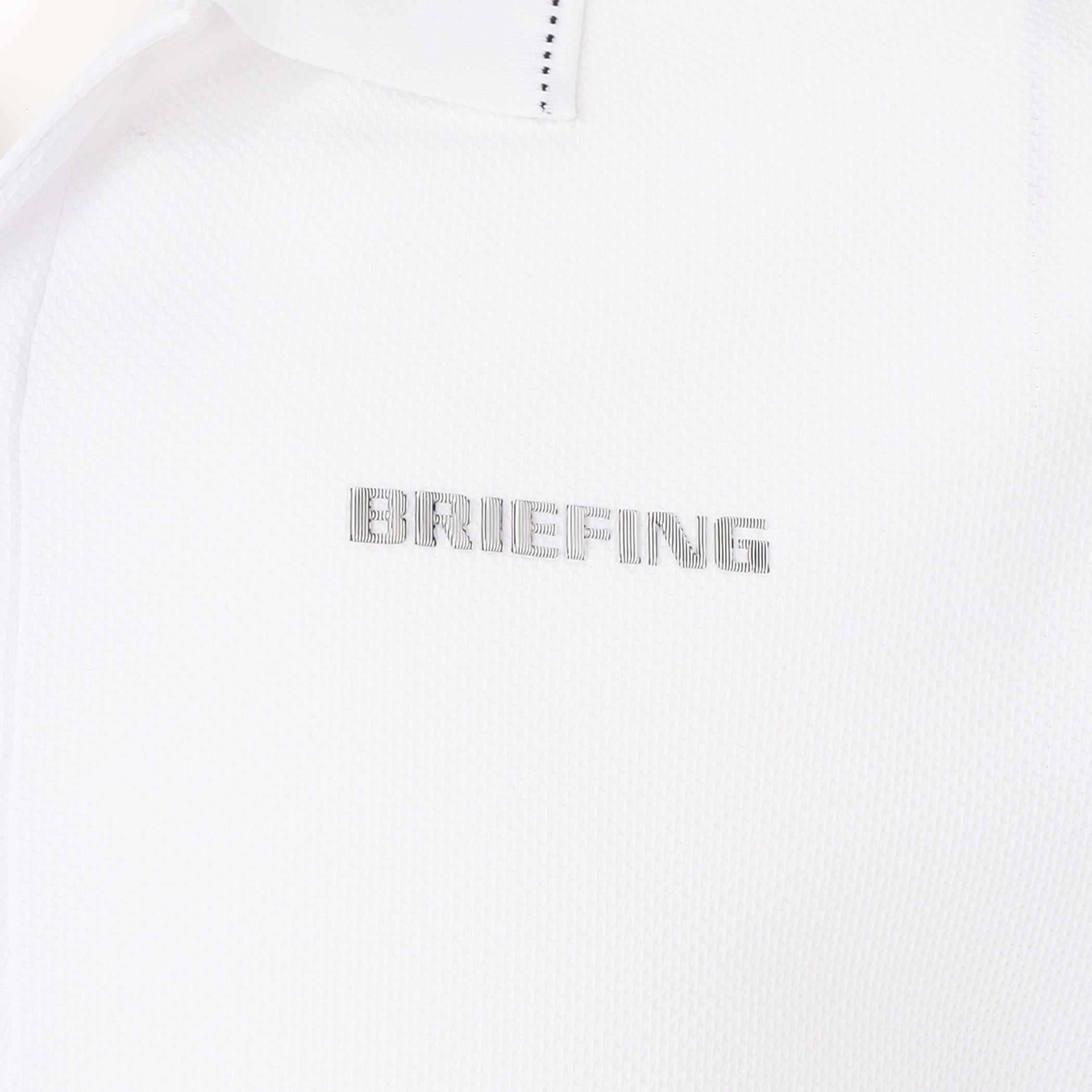 見る角度によって、色みや光沢に変化のあるBRIEFINGロゴを胸元に、袖口にはBマークを配置。