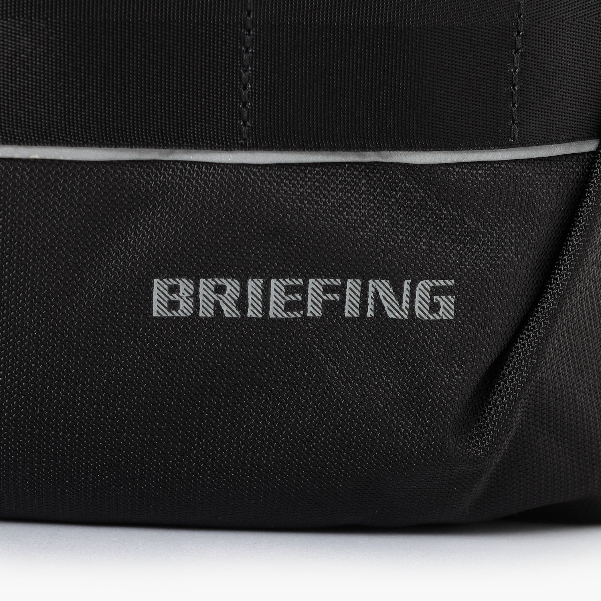 夜間時の移動に配慮し、フロントのBRIEFINGロゴとウェビングテープの下側はリフレクター仕様に。